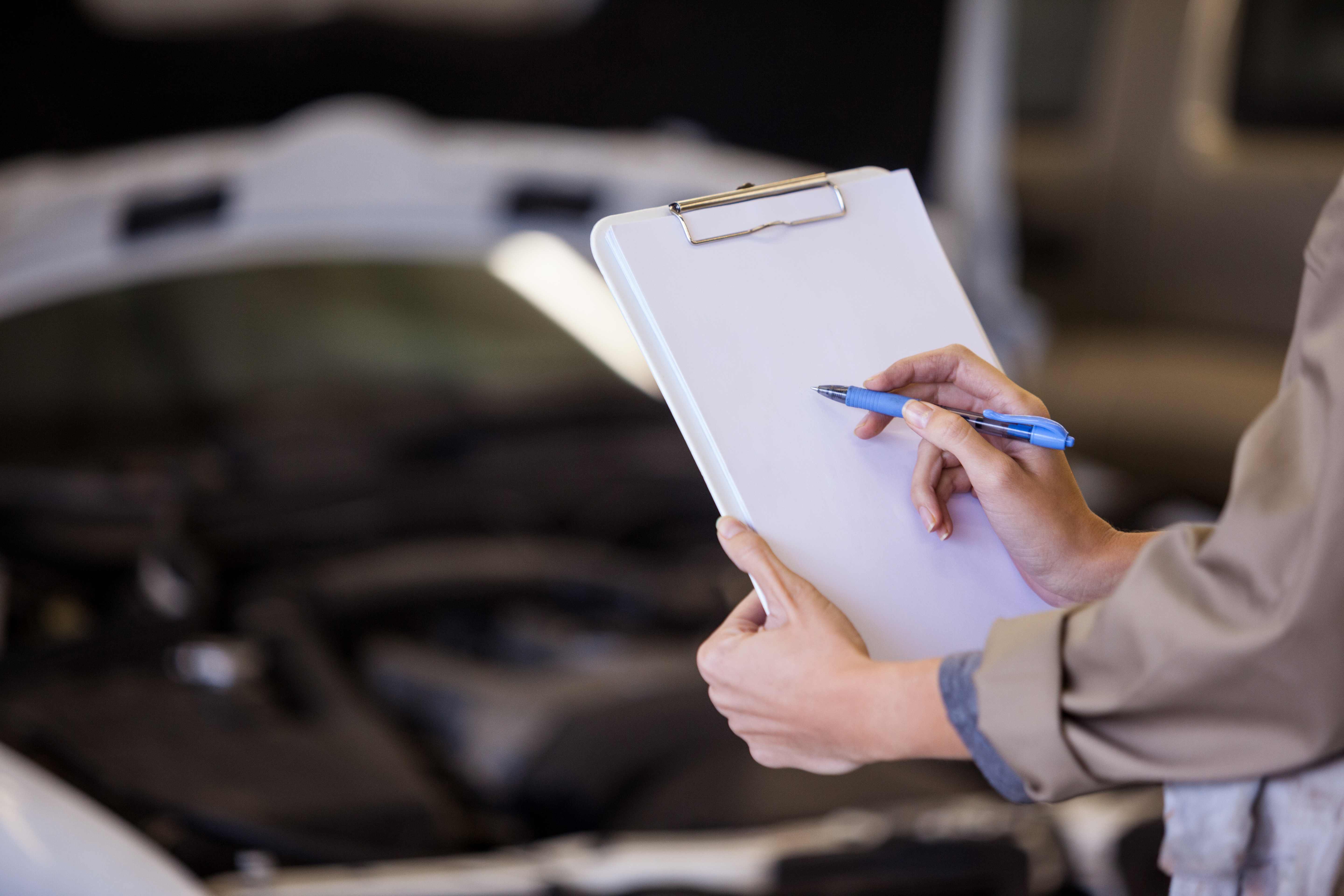 Sachverständiger mit Checkliste bei der Fahrzeugprüfung